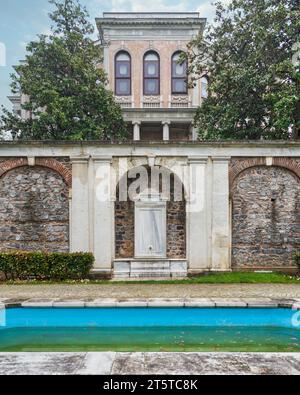 Une belle fontaine en marbre blanc située dans le jardin du pavillon Mecidiye, Istanbul, Turquie, avec une fontaine décorative à l'avant, et le palais en arrière-plan Banque D'Images