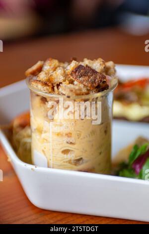 Macaroni et fromage avec croûtons servis dans un bécher Banque D'Images