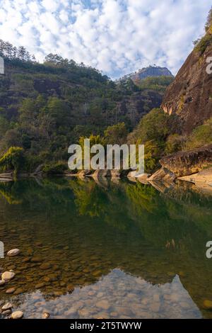 L'eau verte émeraude de la rivière Nine Bend ou de la rivière Jiuxi à travers Wuyishan ou le mont wuyi région pittoresque dans la province de Fujian en Chine. Arrière-plan du coucher du soleil Banque D'Images