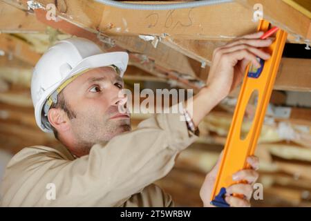 Travailleur de la construction écologique isolant thermique maison à ossature en bois Banque D'Images