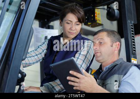 Femme travaillant avec un chariot élévateur dans un entrepôt Banque D'Images