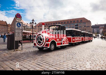 Nuremberg, Allemagne - 25 octobre 2023 : le tramway touristique rouge emmène les passagers dans une visite guidée des célèbres rues de Nuremberg. Gare centrale Banque D'Images