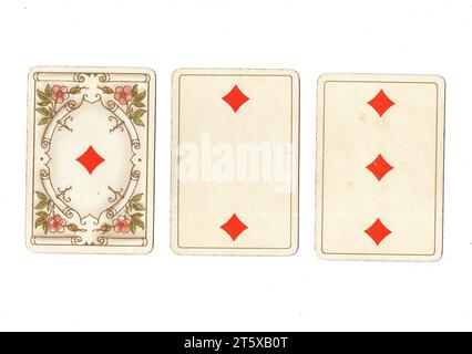 Trois cartes à jouer antiques montrant un as, deux et trois de diamants sur un fond blanc. Banque D'Images