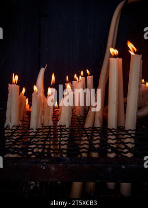 Chambre éclairée aux chandelles, un lieu de dévotion tranquille et de prière, illuminé par une multitude de bougies incandescentes dans l'obscurité Banque D'Images