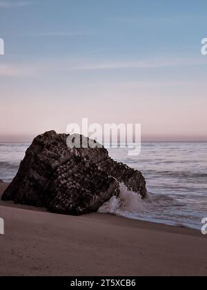 Paysage côtier paisible à Quiaios Beach avec un rocher solitaire sur un rivage serein et tranquille de l'océan Atlantique, capturant la beauté de la nature Banque D'Images