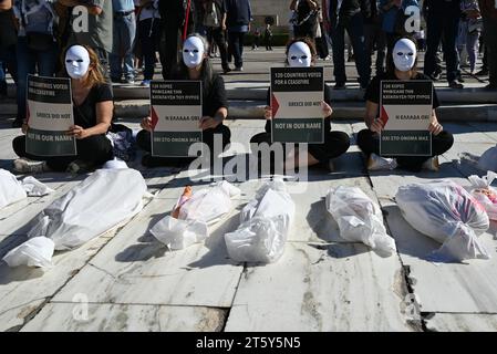 Athènes, Grèce. 5 novembre 2023. Des participants portant des masques blancs et des poupées se tiennent devant le Parlement grec lors d’une manifestation pro-palestinienne. Banque D'Images