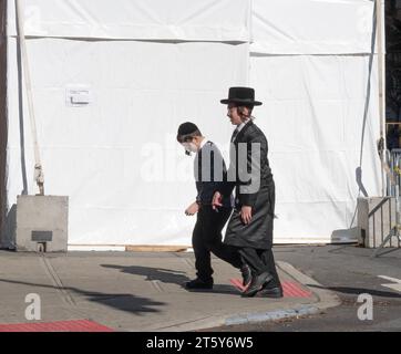 Deux jeunes garçons juifs avec peyus marchent près d'un Sukkah sur Bedford Ave à Williamsburg pendant les vacances de Soukkos. A Brooklyn, New Yok. Banque D'Images