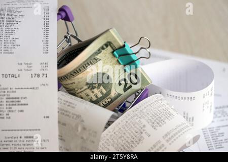 Un tas de dollars AMÉRICAINS dans un chariot entouré de nombreux reçus en papier se rapprochent Banque D'Images