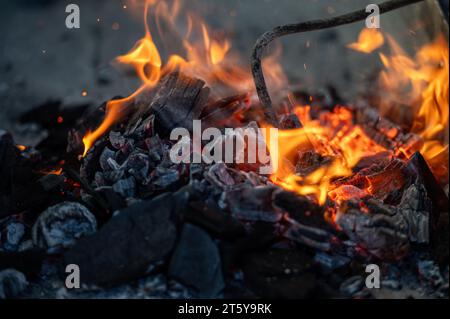 Brulant des charbons dans un feu de camp gros plan. Mise au point sélective. Banque D'Images
