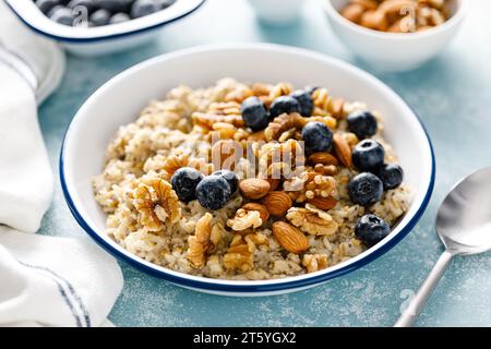 Bouillie d'avoine avec myrtille, amandes, noix, graines de lin, sésame et chia. Nourriture végétarienne saine pour le petit déjeuner Banque D'Images