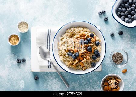 Bouillie d'avoine avec myrtille, amandes, noix, graines de lin, sésame et chia. Nourriture végétarienne saine pour le petit déjeuner, vue de haut en bas Banque D'Images