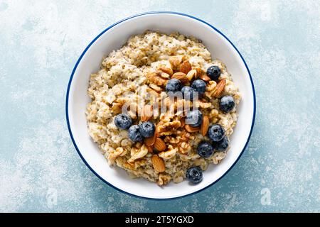 Bouillie d'avoine avec myrtille, amandes, noix, graines de lin, sésame et chia. Nourriture végétarienne saine pour le petit déjeuner, vue de haut en bas Banque D'Images