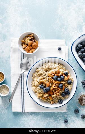 Bouillie d'avoine avec myrtille, amandes, noix, graines de lin, sésame et chia. Nourriture végétarienne saine pour le petit déjeuner, vue de haut en bas Banque D'Images