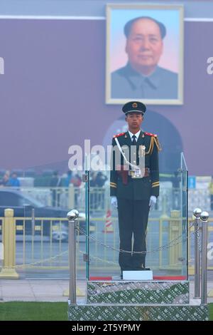 Un soldat de l'Armée de libération des jeunes monte la garde sur la place Tiananmen. Un portrait de Mao Zedong derrière. Pékin, Chine. Banque D'Images