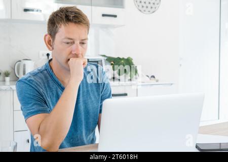 Concentré concentré jeune homme d'affaires travail sur ordinateur portable à la maison. Commerçant professionnel masculin sérieux et courtier travaillant en ligne sur ordinateur avec stock Banque D'Images