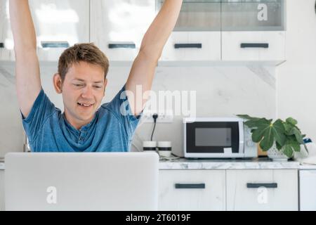 Joyeux jeune commerçant d'affaires prendre pause tout en travaillant sur ordinateur portable se sent satisfait par le travail effectué. Investisseur freelance terminer l'emploi en ligne et Banque D'Images