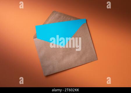 Enveloppe avec une feuille vierge sur un fond coloré, vue de dessus Banque D'Images