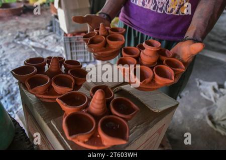 Kolkata, Inde. 06 novembre 2023. Un ouvrier trie une lampe en terre dans le village de poterie nommé Chaltaberia, à environ 40 km de la périphérie de Kolkata au Bengale occidental. Tout le village est en plein rythme de la production de lampes en terre et d'idoles avant le festival Diwali en Inde. Lampes en terre vendues dans toutes les villes indiennes comme Kolkata, Delhi, Mumbai, Hyderabad, Gujarat, Assam, Patna et Rajasthan, surtout pendant la saison des festivals. Même les lampes en terre sont exportées vers l'extérieur de l'Inde avant les célébrations de Diwali. (Photo Dipayan Bose/SOPA Images/Sipa USA) crédit : SIPA USA/Alamy Live News Banque D'Images