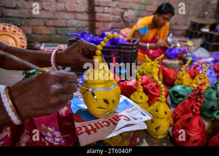 Kolkata, Inde. 06 novembre 2023. Un ouvrier colore une lampe en terre dans le village de poterie nommé Chaltaberia, à environ 40 km de la périphérie de Kolkata au Bengale occidental. Tout le village est en plein rythme de la production de lampes en terre et d'idoles avant le festival Diwali en Inde. Lampes en terre vendues dans toutes les villes indiennes comme Kolkata, Delhi, Mumbai, Hyderabad, Gujarat, Assam, Patna et Rajasthan, surtout pendant la saison des festivals. Même les lampes en terre sont exportées vers l'extérieur de l'Inde avant les célébrations de Diwali. (Photo Dipayan Bose/SOPA Images/Sipa USA) crédit : SIPA USA/Alamy Live News Banque D'Images