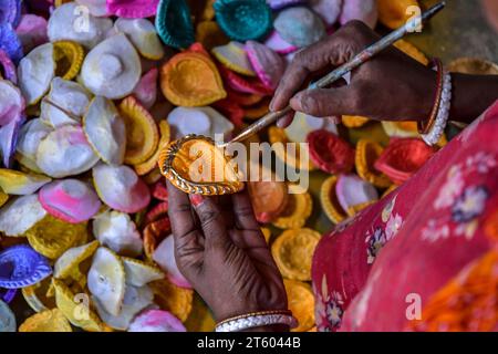 Kolkata, Inde. 06 novembre 2023. Un ouvrier colore une lampe en terre dans le village de poterie nommé Chaltaberia, à environ 40 km de la périphérie de Kolkata au Bengale occidental. Tout le village est en plein rythme de la production de lampes en terre et d'idoles avant le festival Diwali en Inde. Lampes en terre vendues dans toutes les villes indiennes comme Kolkata, Delhi, Mumbai, Hyderabad, Gujarat, Assam, Patna et Rajasthan, surtout pendant la saison des festivals. Même les lampes en terre sont exportées vers l'extérieur de l'Inde avant les célébrations de Diwali. (Photo Dipayan Bose/SOPA Images/Sipa USA) crédit : SIPA USA/Alamy Live News Banque D'Images