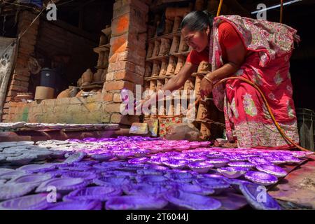 Kolkata, Inde. 06 novembre 2023. Un ouvrier colore une lampe en terre dans le village de poterie nommé Chaltaberia, à environ 40 km de la périphérie de Kolkata au Bengale occidental. Tout le village est en plein rythme de la production de lampes en terre et d'idoles avant le festival Diwali en Inde. Lampes en terre vendues dans toutes les villes indiennes comme Kolkata, Delhi, Mumbai, Hyderabad, Gujarat, Assam, Patna et Rajasthan, surtout pendant la saison des festivals. Même les lampes en terre sont exportées vers l'extérieur de l'Inde avant les célébrations de Diwali. (Photo Dipayan Bose/SOPA Images/Sipa USA) crédit : SIPA USA/Alamy Live News Banque D'Images