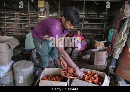 Kolkata, Inde. 06 novembre 2023. Un ouvrier trie une lampe en terre dans le village de poterie nommé Chaltaberia, à environ 40 km de la périphérie de Kolkata au Bengale occidental. Tout le village est en plein rythme de la production de lampes en terre et d'idoles avant le festival Diwali en Inde. Lampes en terre vendues dans toutes les villes indiennes comme Kolkata, Delhi, Mumbai, Hyderabad, Gujarat, Assam, Patna et Rajasthan, surtout pendant la saison des festivals. Même les lampes en terre sont exportées vers l'extérieur de l'Inde avant les célébrations de Diwali. (Photo Dipayan Bose/SOPA Images/Sipa USA) crédit : SIPA USA/Alamy Live News Banque D'Images