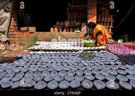 Kolkata, Bengale occidental, Inde. 6 novembre 2023. Une femme trie des lampes en terre avant de se faire peindre dans le village de poterie nommé Chaltaberia, à environ 40 km de la périphérie de Kolkata au Bengale occidental. Tout le village est en plein rythme de la production de lampes en terre et d'idoles avant le festival Diwali en Inde. Lampes en terre vendues dans toutes les villes indiennes comme Kolkata, Delhi, Mumbai, Hyderabad, Gujarat, Assam, Patna et Rajasthan, surtout pendant la saison des festivals. Même les lampes en terre sont exportées vers l'extérieur de l'Inde avant les célébrations de Diwali. (Image de crédit : © Dipayan Bose/SOPA Images via zu Banque D'Images