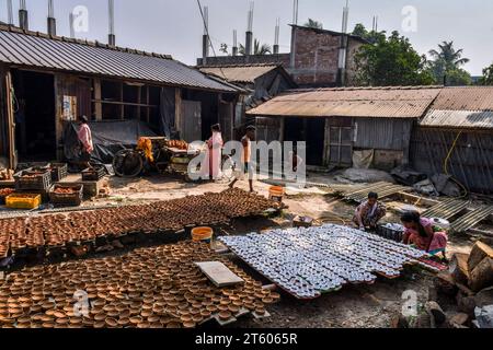 Kolkata, Bengale occidental, Inde. 6 novembre 2023. Une famille de poteries est occupée à trier et à colorer des lampes en terre dans le village de poterie nommé Chaltaberia, à environ 40 km de la périphérie de Kolkata dans le Bengale occidental. Tout le village est en plein rythme de la production de lampes en terre et d'idoles avant le festival Diwali en Inde. Lampes en terre vendues dans toutes les villes indiennes comme Kolkata, Delhi, Mumbai, Hyderabad, Gujarat, Assam, Patna et Rajasthan, surtout pendant la saison des festivals. Même les lampes en terre sont exportées vers l'extérieur de l'Inde avant les célébrations de Diwali. (Image de crédit : © Dipayan Bose/SOPA Images vi Banque D'Images