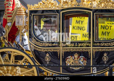 Londres, Royaume-Uni. 7 novembre 2023. Des affiches avec 'pas mon Roi' écrit dessus alors que le Roi Charles et les membres de la famille royale se déplacent en procession pour l'ouverture d'État du Parlement avant son discours. Le Roi ouvrira le Parlement pour la première fois en tant que monarque. Les manifestants anti-monarchie ont hué le roi Charles III à son arrivée à Westminster. (Image de crédit : © Velar Grant/ZUMA Press Wire) USAGE ÉDITORIAL SEULEMENT! Non destiné à UN USAGE commercial ! Banque D'Images