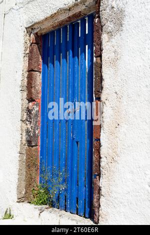 Une porte ou un portail en bois bleu, fermé, forme l'entrée d'une propriété en Grèce. Banque D'Images