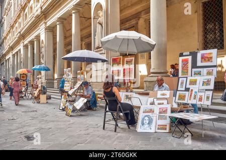 Florence, Toscane, Italie - 21 septembre 2023 : les peintres peignent le portrait d'une femme touriste à Piazzale degli Uffizi, statue de Dante Alighieri A. Banque D'Images