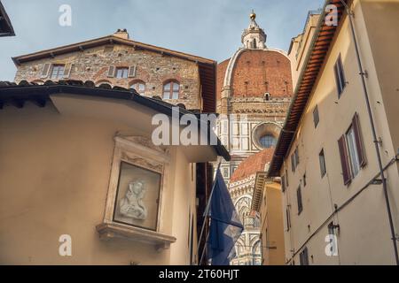 Coupole de Brunelleschi de la cathédrale de Santa Maria del Fiore à Florence vue d'une petite rue, à gauche un sanctuaire de la Vierge Marie Banque D'Images