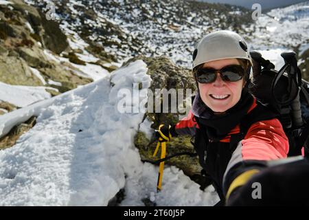 Mountaineer prenant selfie sur terrain enneigé pendant la randonnée Banque D'Images