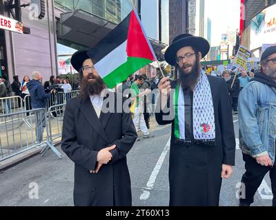 Rassemblement pro-palestinien à Times Square vendredi 13 octobre 2023 alors que Gaza est bombardée par Israël après les attaques terroristes du Hamas contre Israël qui ont brutalement tué de nombreux civils. Des hommes juifs orthodoxes antisionistes se tiennent avec la cause palestinienne avec le drapeau à la main. Un juif orthodoxe antisioniste tient un drapeau palestinien pendant la manifestation. Banque D'Images