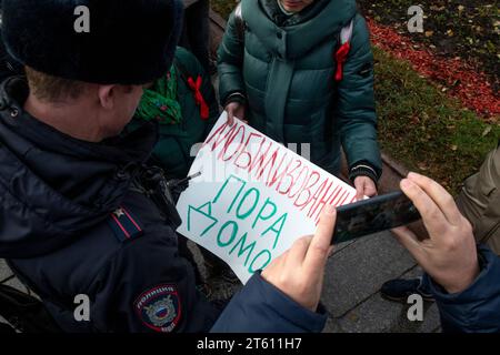 Moscou, Russie. 7 novembre 2023. Les policiers vérifient les banderoles des proches des militaires mobilisés qui exigent de les ramener chez eux lors d'un rassemblement du Parti communiste russe pour marquer les 106 ans de la Révolution d'octobre, dans le centre de Moscou, en Russie. La bannière indique «temps mobilisé pour rentrer à la maison» crédit : Nikolay Vinokurov/Alamy Live News Banque D'Images