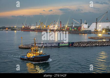 Guatemala, Puerto Quetzal - 20 juillet 2023 : ciel du soir. Plusieurs navires, vrac et conteneur, tous amarrés et travaillant vu du côté de l'océan de pretective Banque D'Images