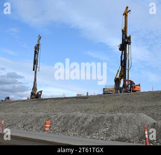 L'équipement de construction est exploité au sommet du remblai en terre de 8 milles de long connu sous le nom de barrage Moose Creek au projet de contrôle des inondations des lacs de la rivière Chena près du pôle Nord, en Alaska. Le U.S. Army corps of Engineers – Alaska District renforce environ 4,7 miles du barrage en installant un mur de barrière en béton mélangé sur place. À l'heure actuelle, le projet d'amélioration de la sécurité est presque à mi-parcours et les travaux devraient être effectués d'ici janvier 2026. Banque D'Images