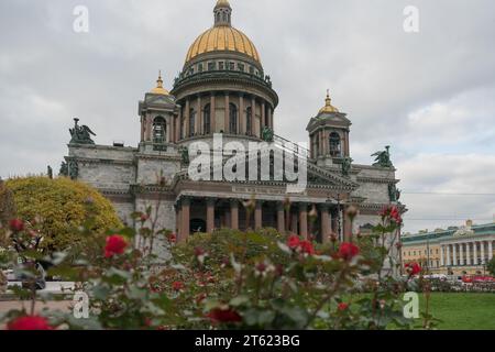 Vue d'en bas sur la façade de la cathédrale Saint-Isaac avec des roses poussant devant elle et signe en russe signifiant que mon temple sera appelé le temple de Banque D'Images