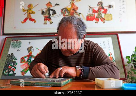 Comté de Luannan - 17 octobre 2016 : un artisan fabriquant des figures de l'ombre, Comté de Luannan, province du Hebei, Chine. Banque D'Images