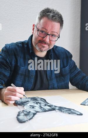 Pforzheim, Allemagne. 07 novembre 2023. Oliver Lemke crée un portrait de chien à partir de perles sur fer dans son appartement. Crédit : Uli Deck/dpa/Alamy Live News Banque D'Images