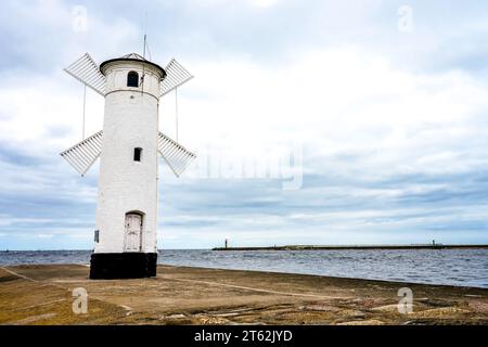 Mühlenbake à Swinoujscie sur la mer Baltique. Tour ronde en pierre avec quatre pales de moulin à vent. Une marque de navigation pour entrer dans le port. Banque D'Images