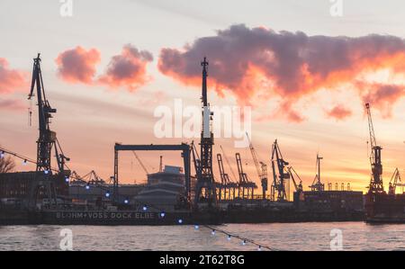 Hambourg, Allemagne - 27 novembre 2018 : Port de Hambourg sur un coucher de soleil. Silhouettes noires de grues et de quais le long de la côte de l'Elbe Banque D'Images