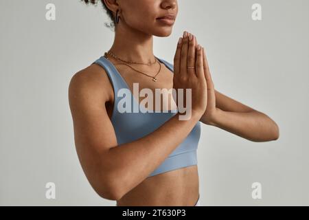 Gros plan minimal de jeune femme noire méditant avec les yeux fermés dans le studio de yoga, espace de copie Banque D'Images