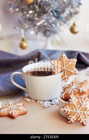 Mise en place de la table d'hiver. Mignons biscuits au gingembre flocons de neige et café chaud. Esthétique nourriture de Noël. Maison chaleureuse et confortable. Du temps pour vous. Banque D'Images