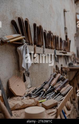 Un assortiment d'outils de menuiserie bien utilisés méticuleusement organisés contre un mur rustique dans un atelier traditionnel de Tolède Banque D'Images