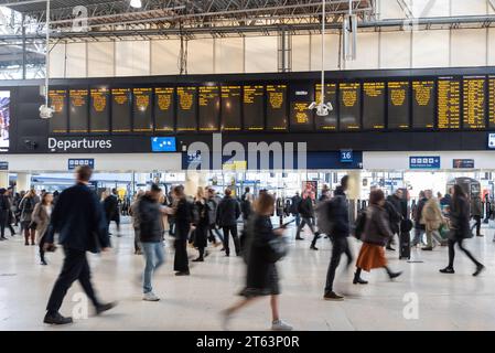 Heure de pointe à la gare de Waterloo à Londres, les gens qui vont dans toutes les directions rapidement montré avec une vitesse d'obturation lente. Nov 2023. Banque D'Images