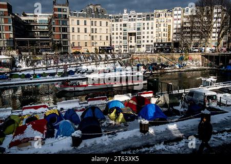 Michael Bunel/le Pictorium - exil au pays des droits de l'homme - 09/02/2018 - France/Ile-de-France (région)/Paris - face aux barges, des réfugiés ont installé leur camp sur les rives du Canal Saint-Martin. Ils passent la nuit dans des tentes malgré des températures inférieures à zéro. 7 février 2018. Paris. France. En octobre 2015, la municipalité a présenté dix-huit engagements dans un document intitulé « mobiliser la communauté parisienne pour accueillir les réfugiés ». Le document s'ouvre sur cette phrase : « Paris, comme d'autres villes de réfugiés, relèvera le défi d'accueillir les nombreux migrants actuels Banque D'Images