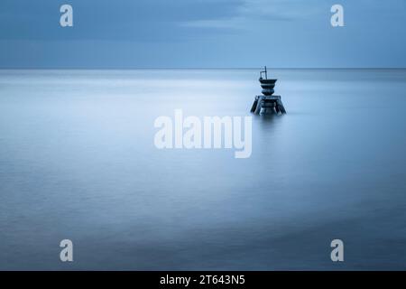 The Time and Tide Bell par le sculpteur Marcus Vergette à Happisburg, Norfolk, un matin nuageux calme avant le lever du soleil. Banque D'Images