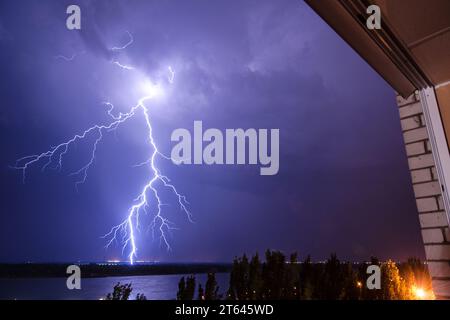 Vue depuis la fenêtre sur une tempête de nuit et la foudre. Banque D'Images