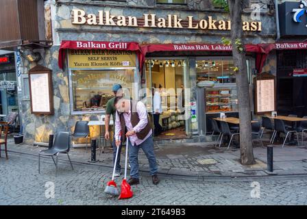 Istanbul, Turquie, le 11 octobre 2023, Un homme turc nettoie devant les restaurants dans le quartier Karakoy d'Istanbul, éditorial seulement. Banque D'Images